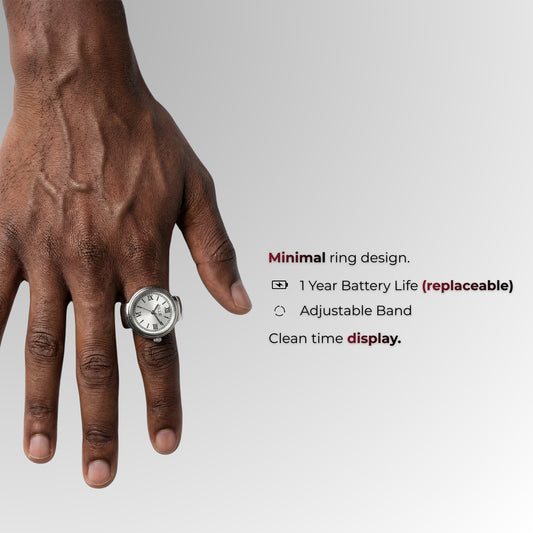 Hand met een ring met horloge-ontwerp op een grijze achtergrond