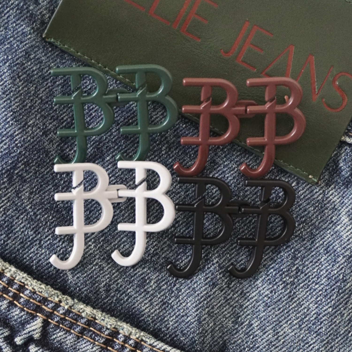 Four signature waist knots in green, red, white, and black on a denim background with 'BILLIE JEANS' branding.