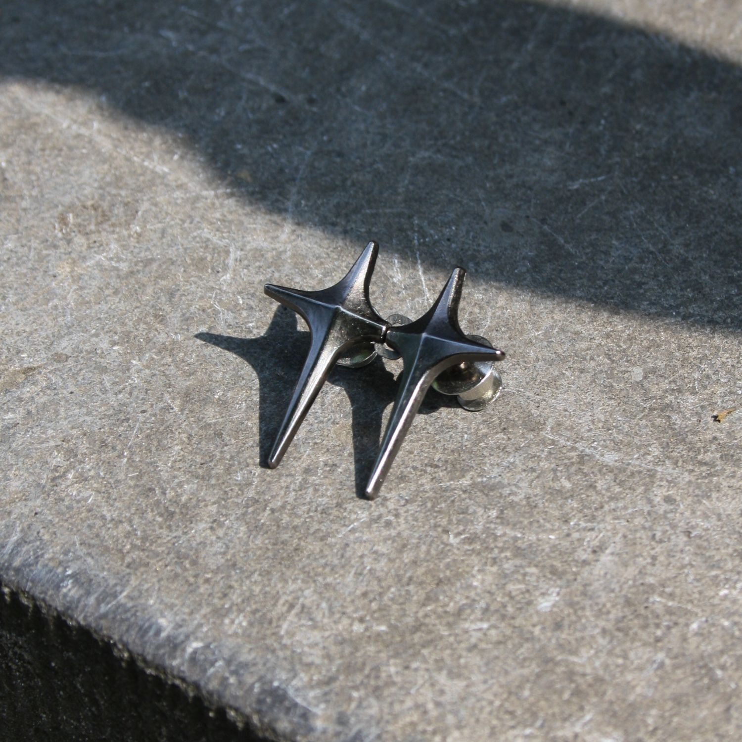 Pair of silver metallic waist knot on a stone surface