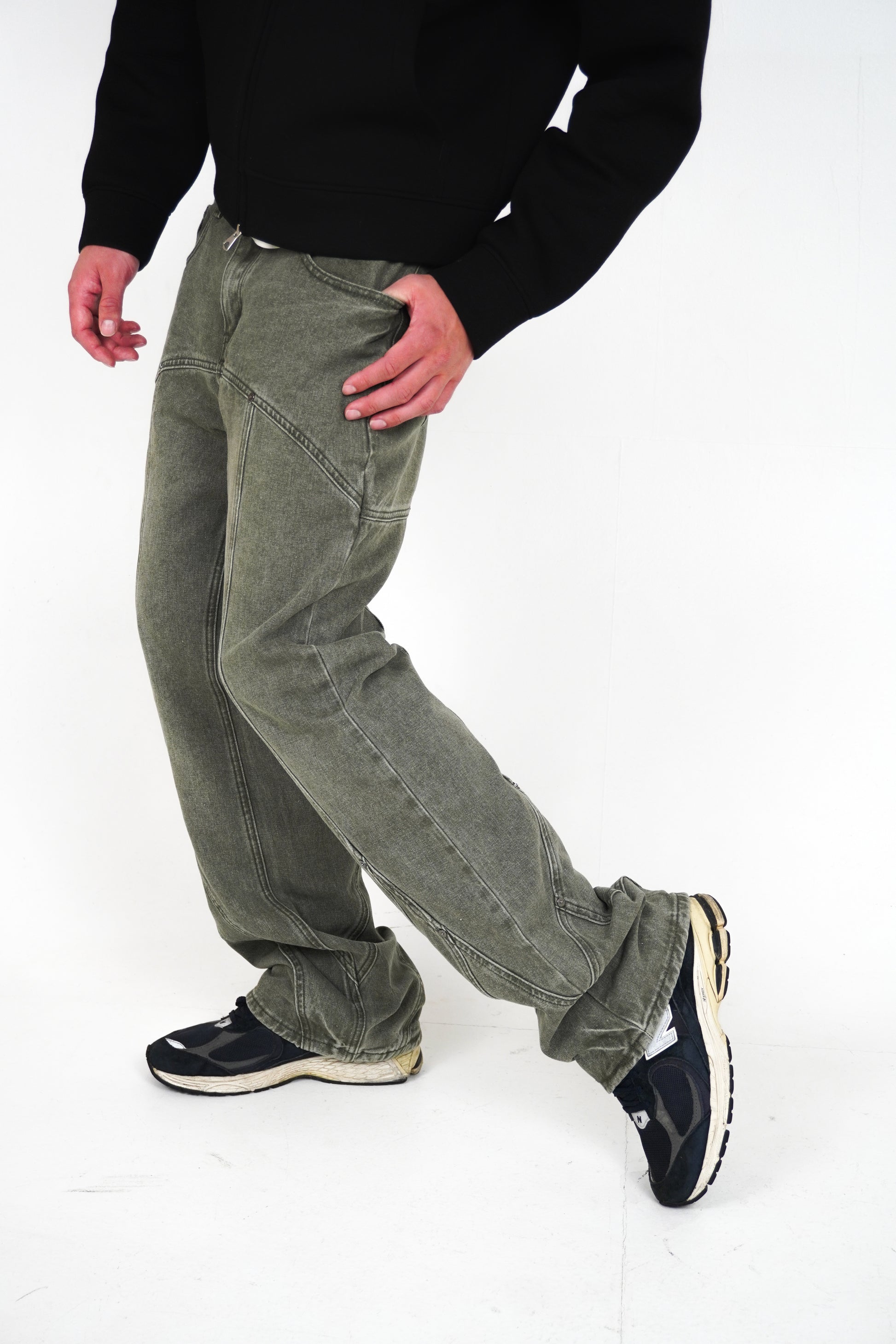 Person wearing green corduroy pants and black shoes on a white background