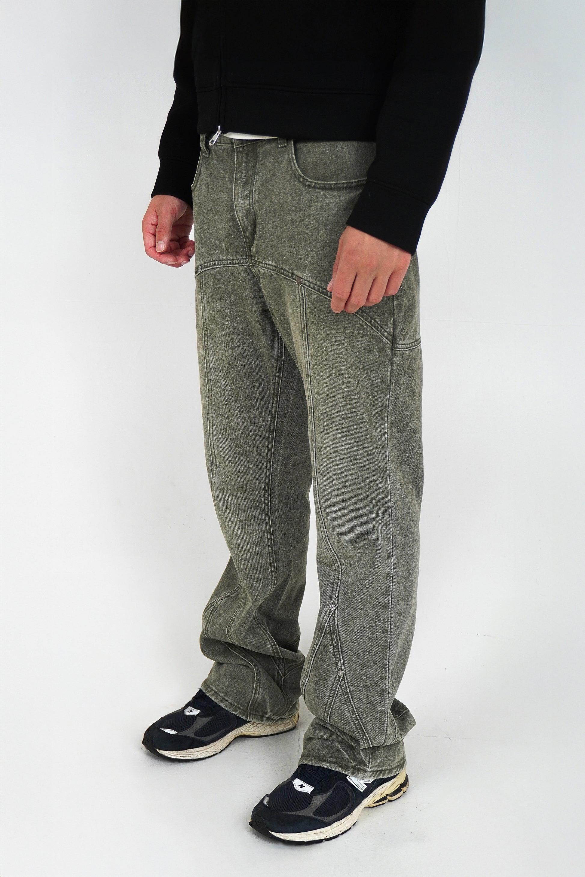 Person wearing flared jeans and black shoes on a white background
