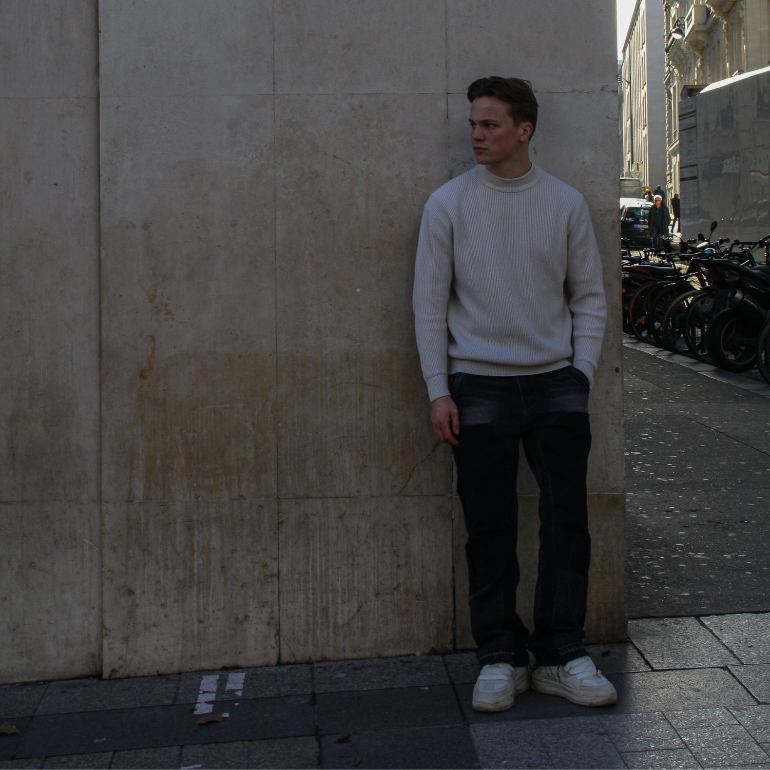 Man leaning against a wall on a city street