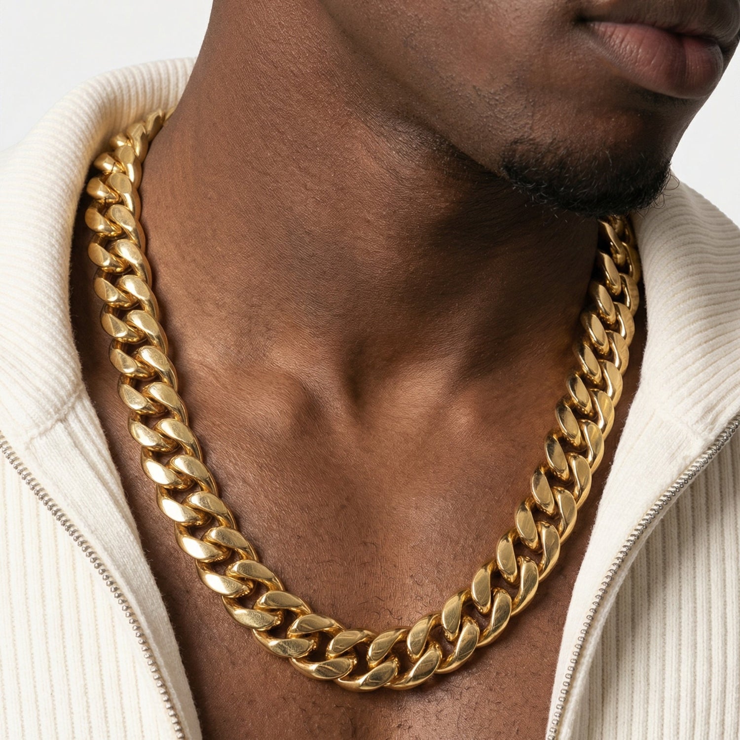 Gold Cuban link chain necklace worn with white jacket