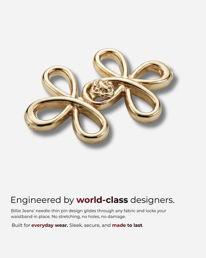 Two gold decorative pins with a loop design on a light background.