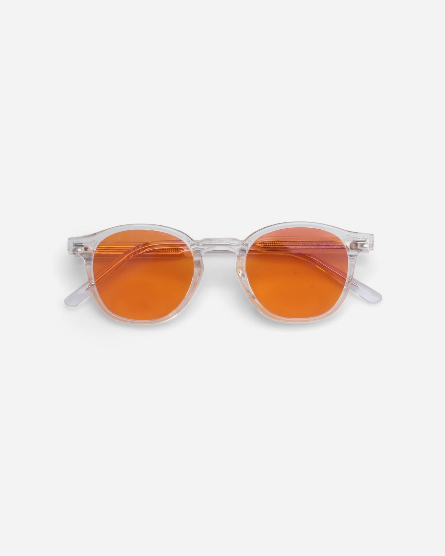 Round sunglasses with clear frames and orange lenses on a plain background.