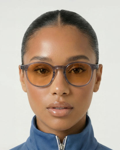Woman wearing the Billie Blue Light Glasses in gray with orange lenses, front view