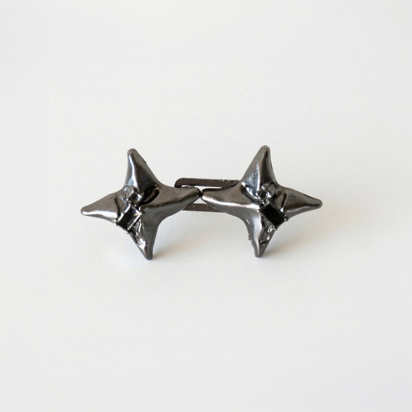 Pair of black star-shaped earrings on a white background