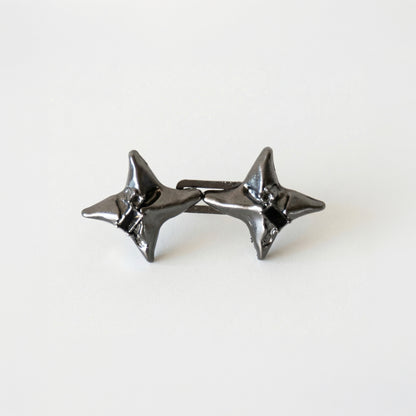 Pair of black star-shaped earrings on a white background