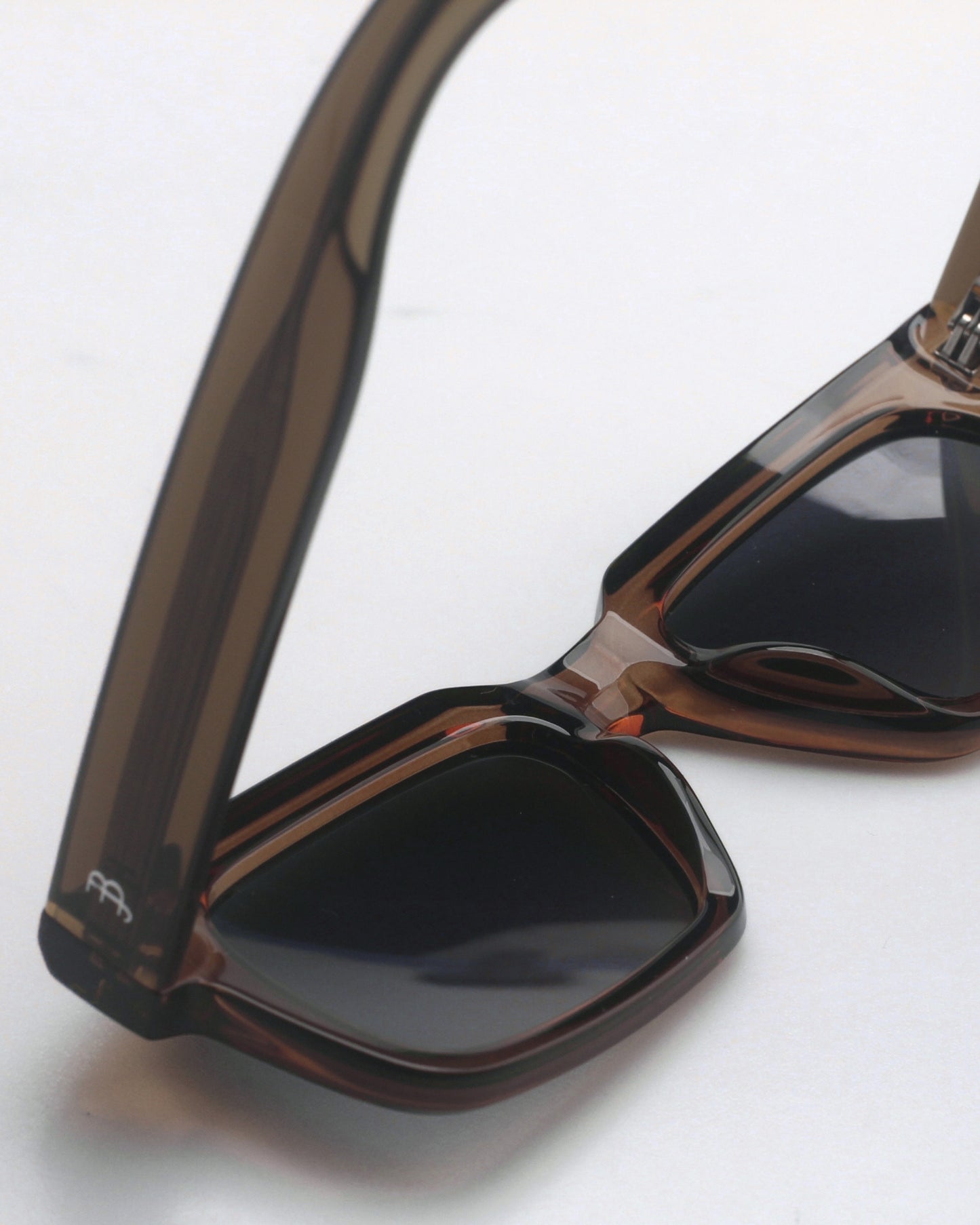 Brown sunglasses with dark lenses on a plain background