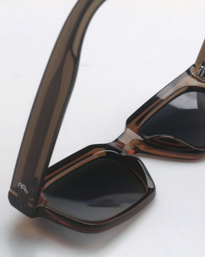 Brown sunglasses with dark lenses on a plain background