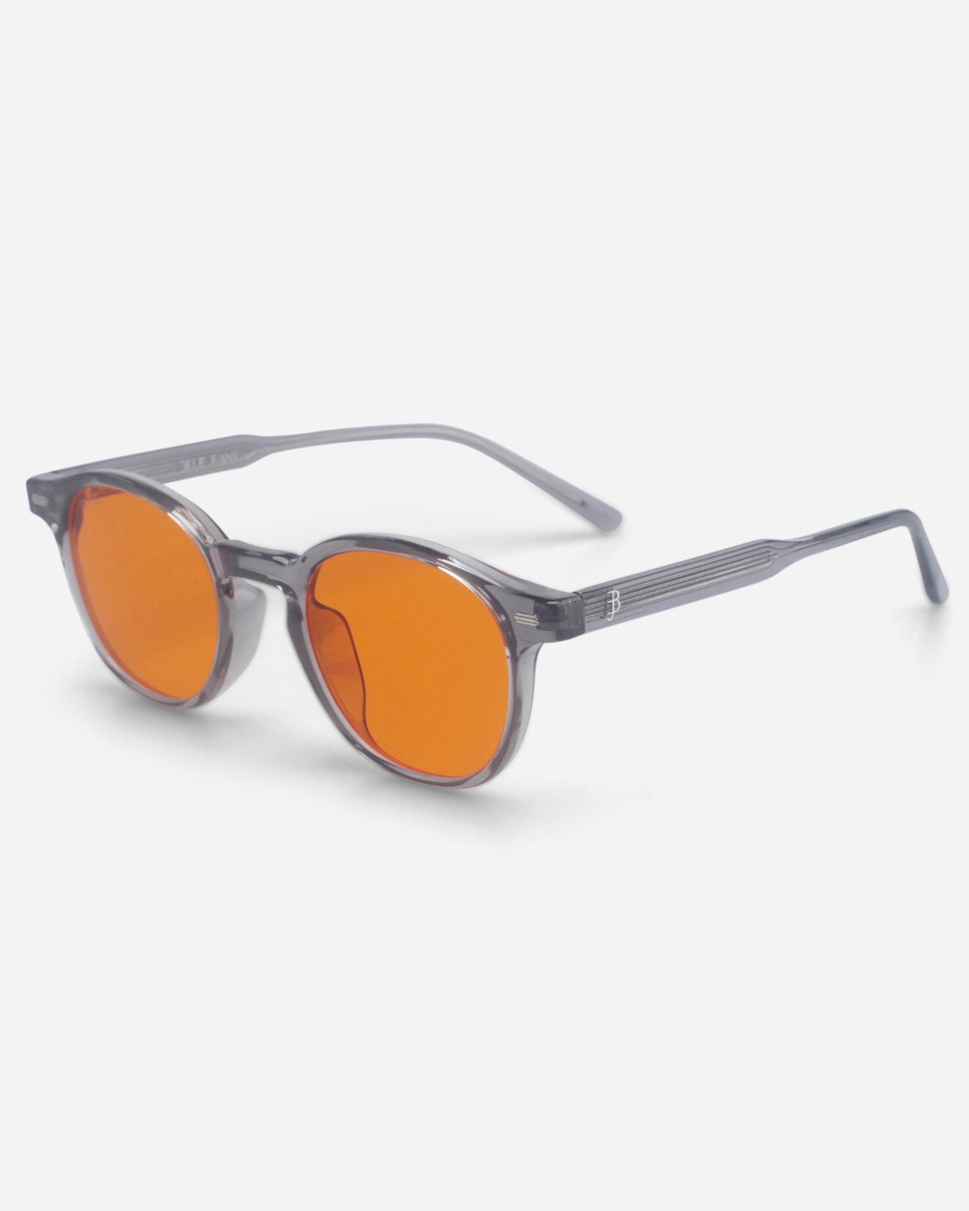 Gray sunglasses with orange lenses on a plain background