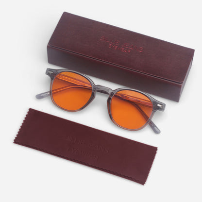 Round sunglasses with orange lenses and a matching case on a white background