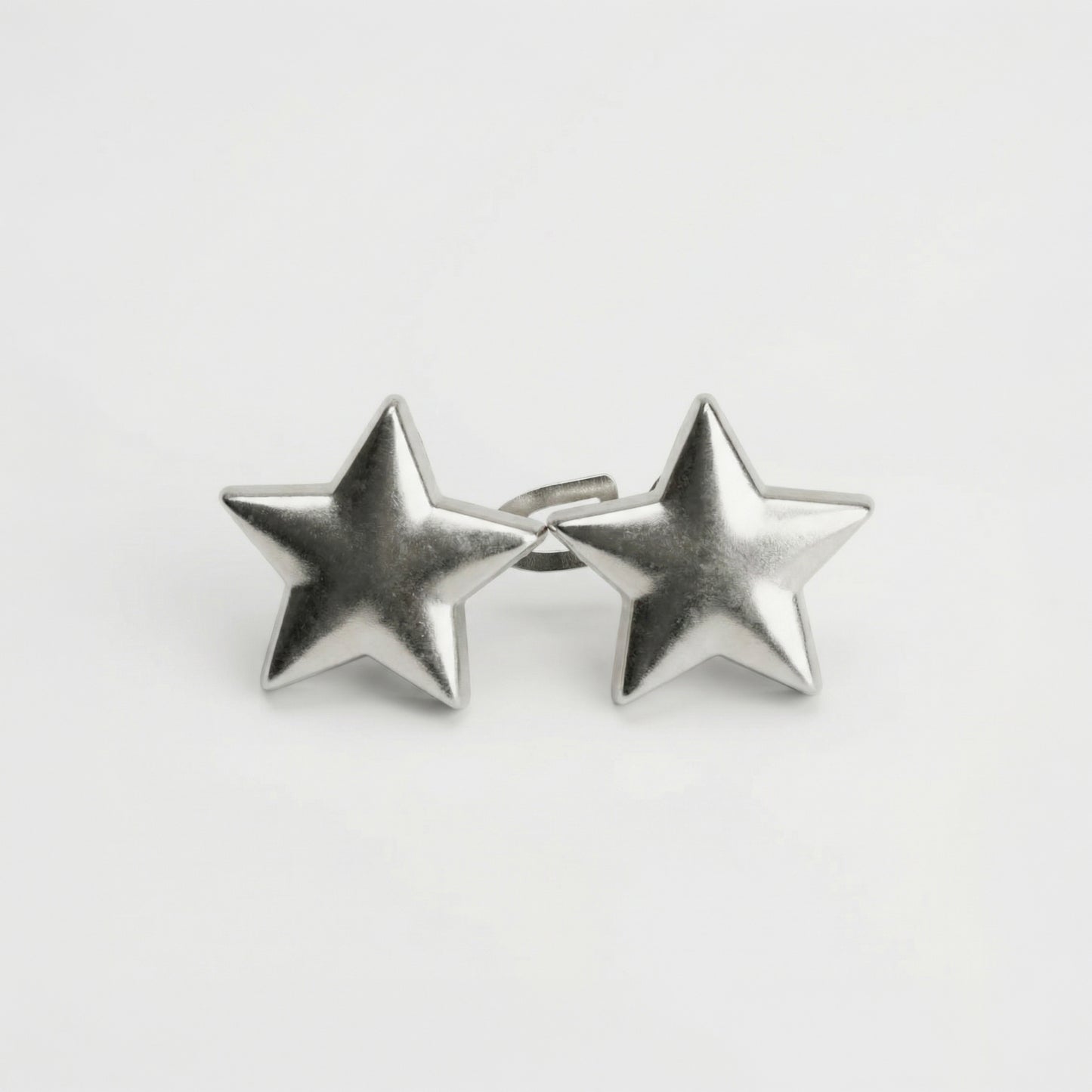 Pair of silver star-shaped earrings on a light gray background