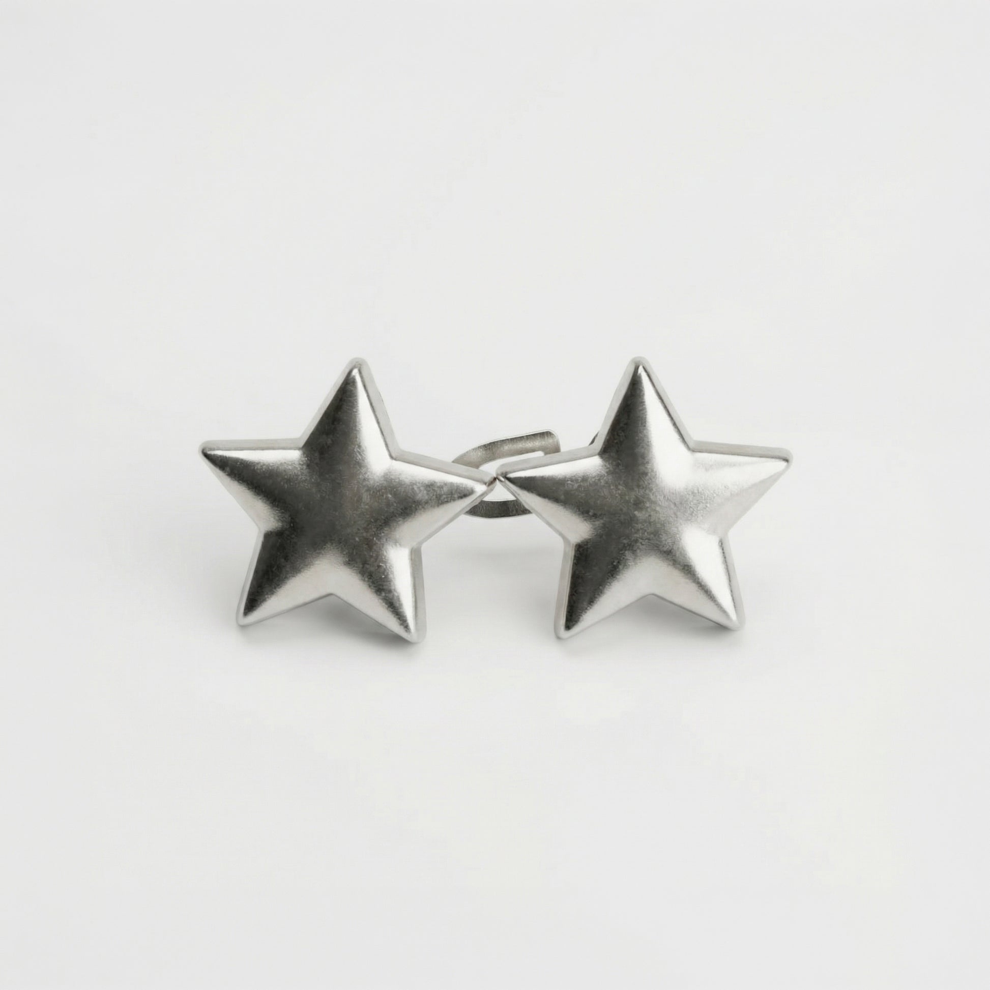 Pair of silver star-shaped earrings on a light gray background
