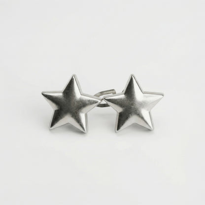 Pair of silver star-shaped earrings on a light gray background