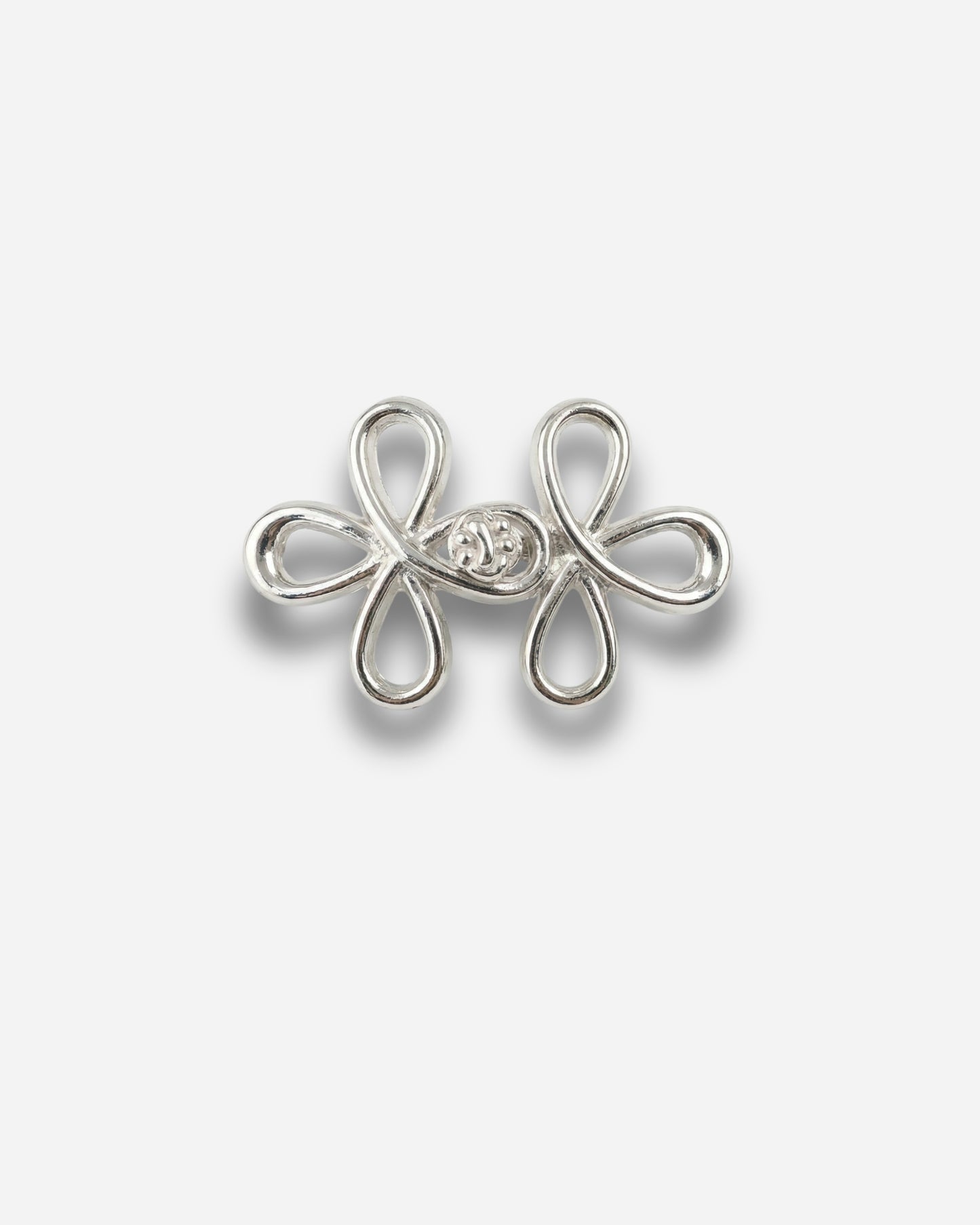 Silver decorative clasp with a floral design on a plain white background.