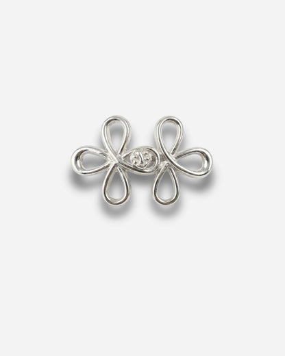 Silver decorative clasp with a floral design on a plain white background.
