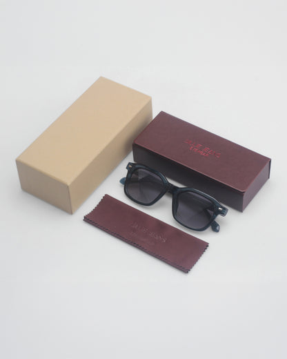 Sunglasses on a plain background with two boxes and a cleaning cloth.