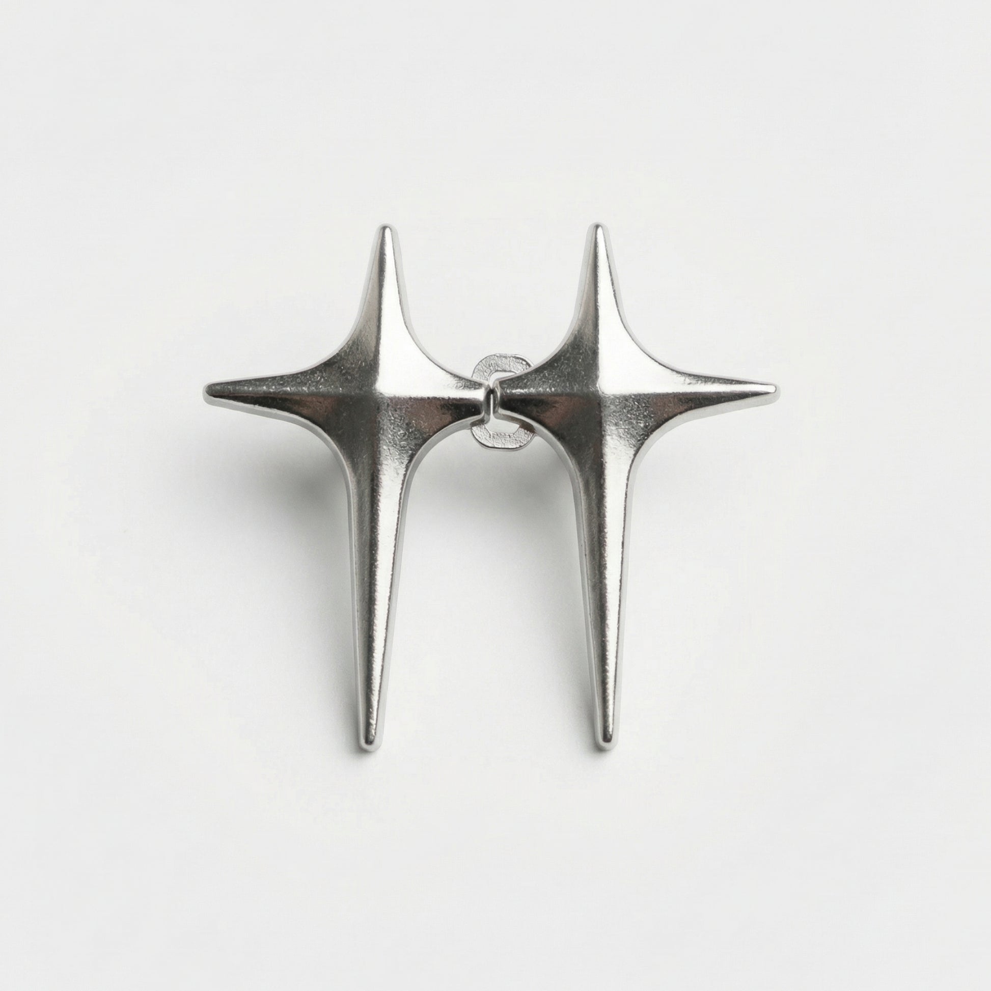 Pair of silver star-shaped earrings on a light gray background
