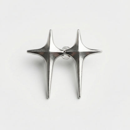 Pair of silver star-shaped earrings on a light gray background