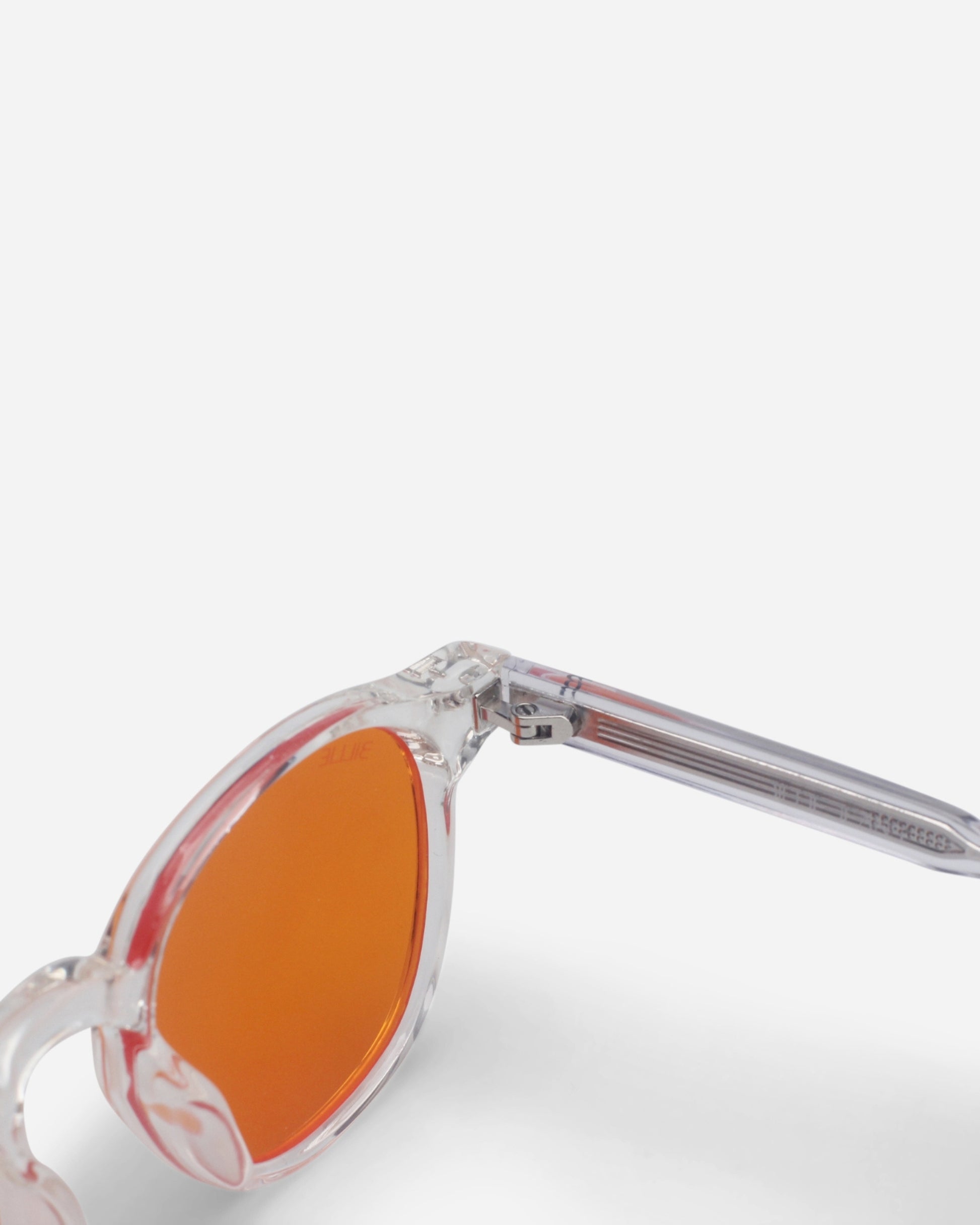 Clear sunglasses with orange lenses on a plain white background