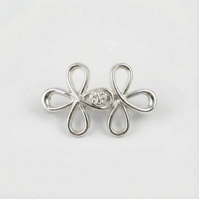 Silver flower-shaped earring with a central gemstone on a light gray background