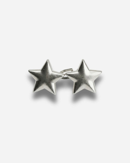 Silver star-shaped earrings on a plain background