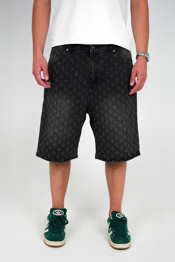 Person wearing black patterned shorts on a white background
