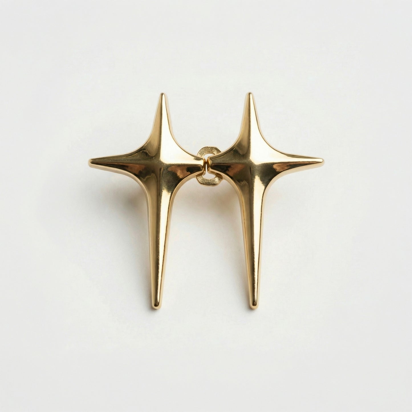 Gold star-shaped earring on a light gray background