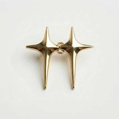 Gold star-shaped earring on a light gray background