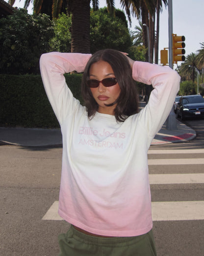Woman in sunglasses wearing the Billie Long Sleeve Fade on a street lined with palm trees