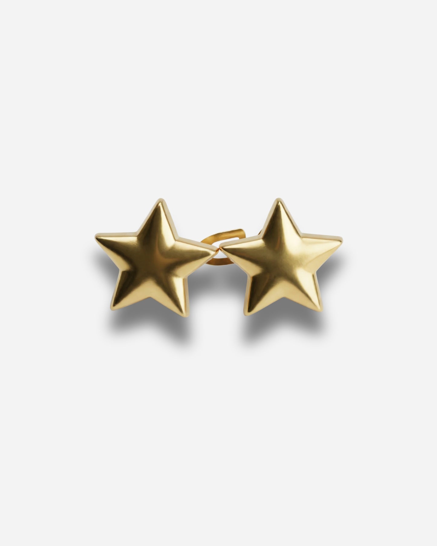 Gold star-shaped earrings on a plain background