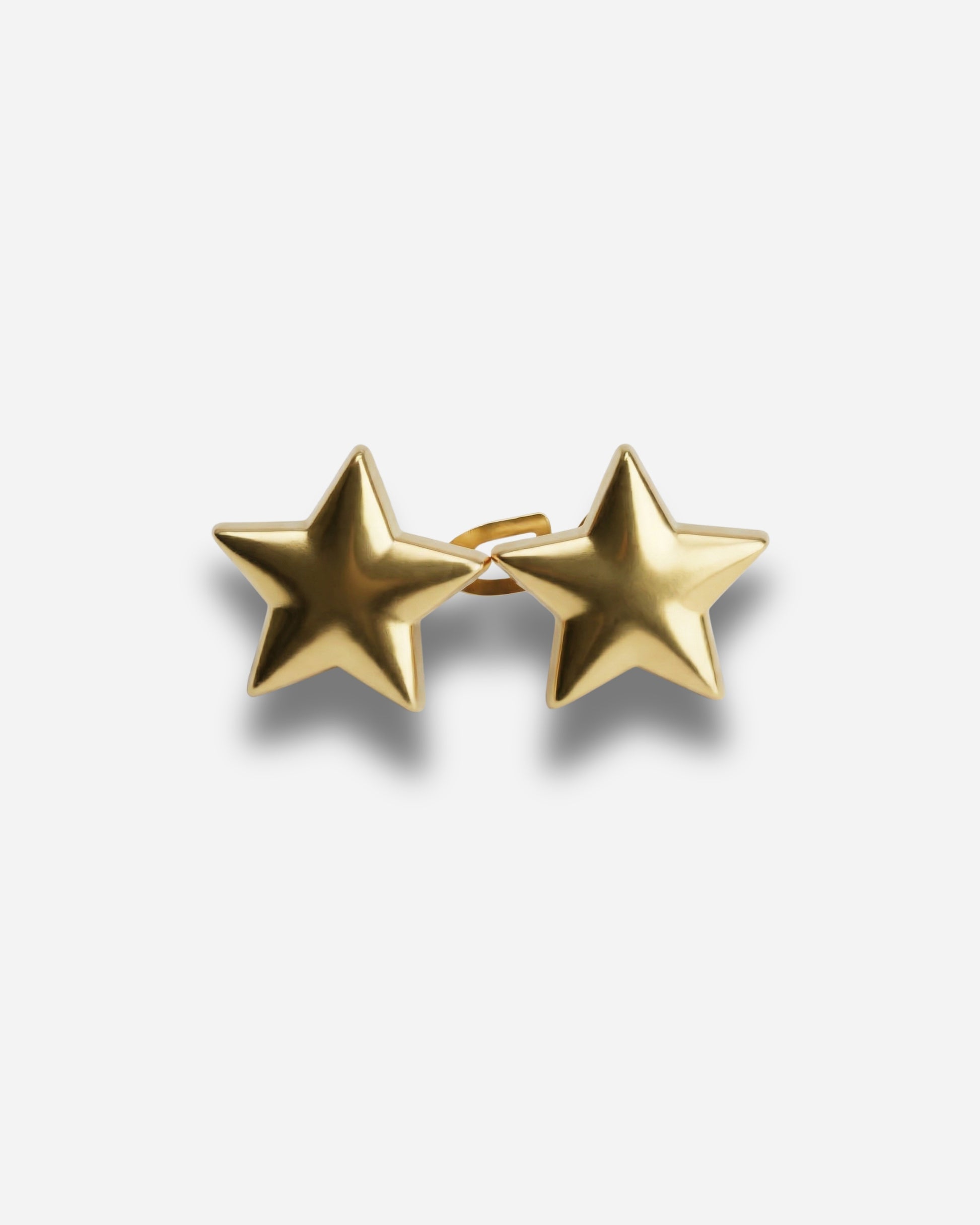 Gold star-shaped earrings on a plain background