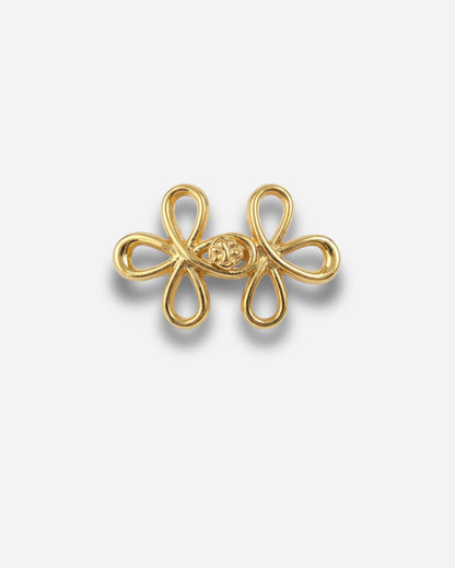Gold decorative clasp with a floral design on a plain white background.