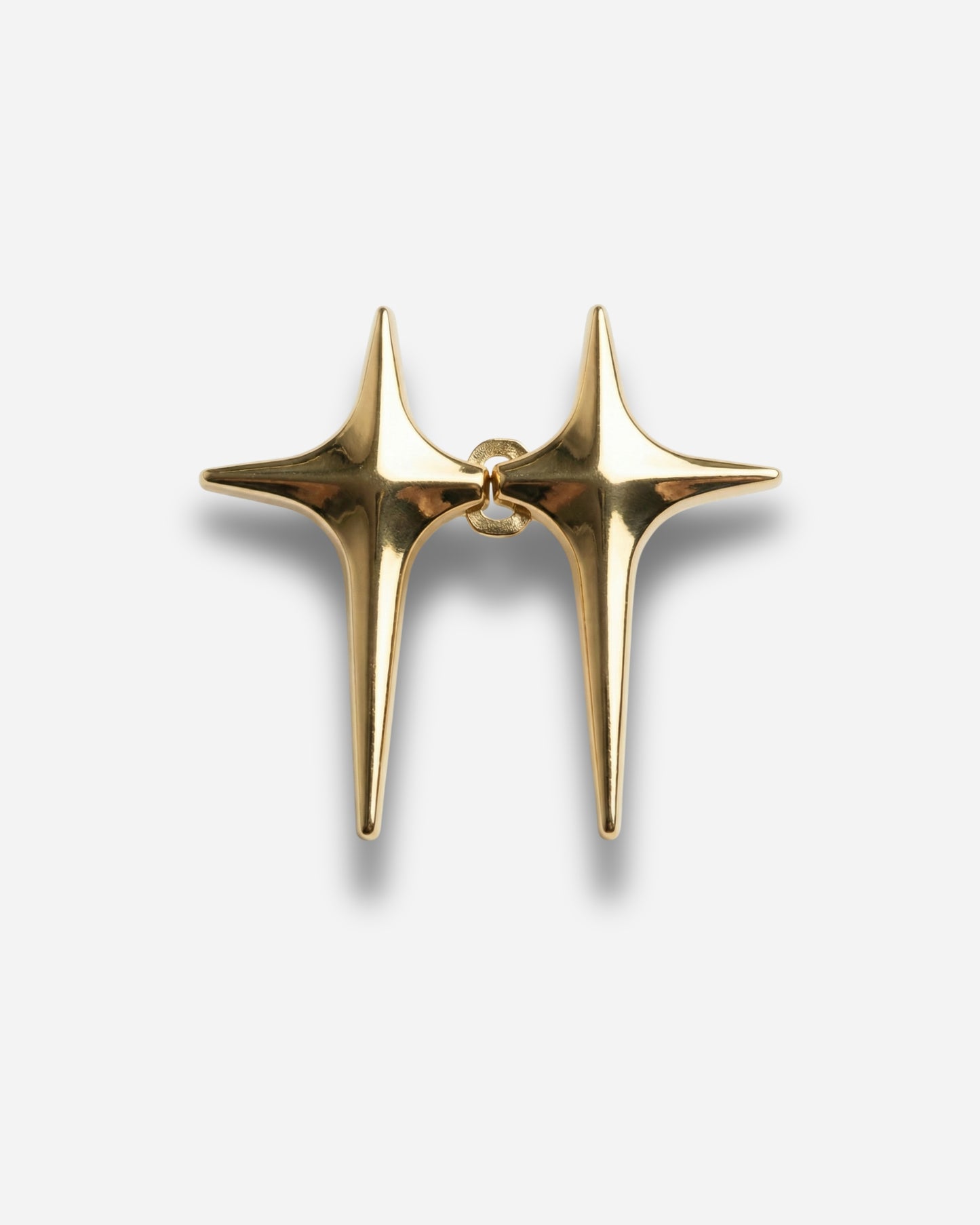 Gold star-shaped earrings with pointed ends on a plain background.