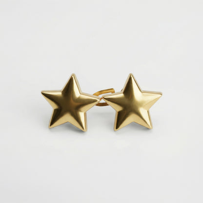 Gold star-shaped earrings on a light gray background