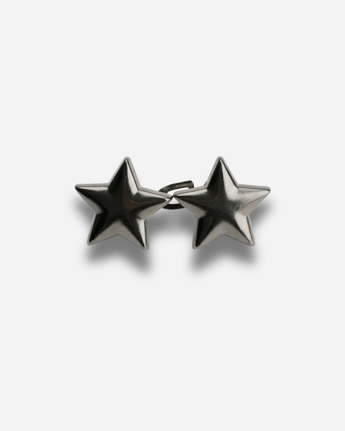Two metallic star-shaped earrings on a plain background.
