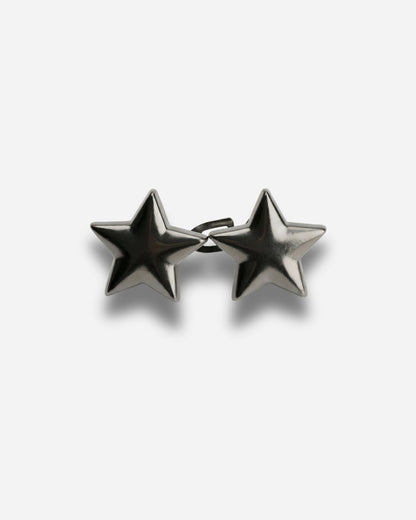 Two metallic star-shaped earrings on a plain background.