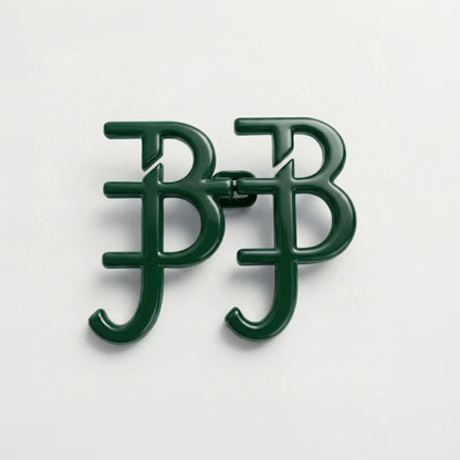 Green metal brooch with 'BB' initials on a white background