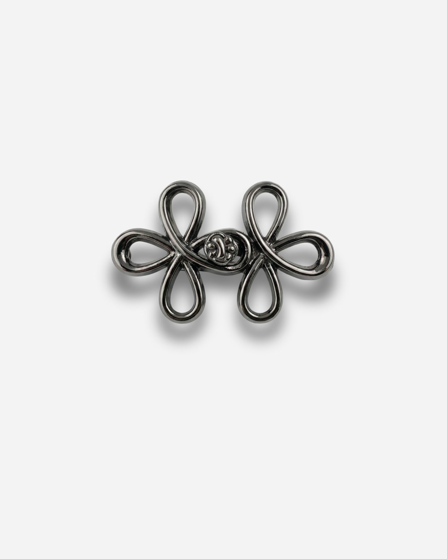 Black decorative clasp with looped design on a plain background