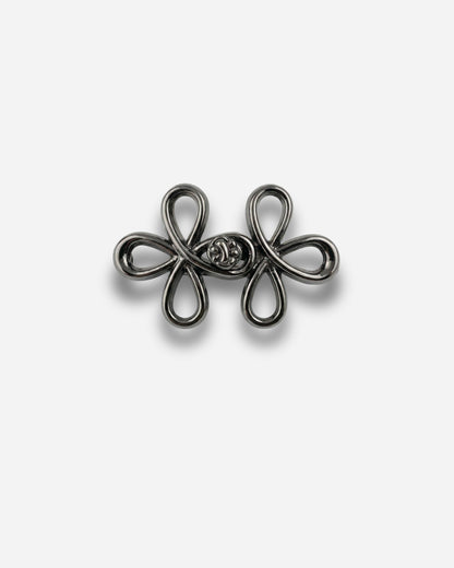 Black decorative clasp with looped design on a plain background