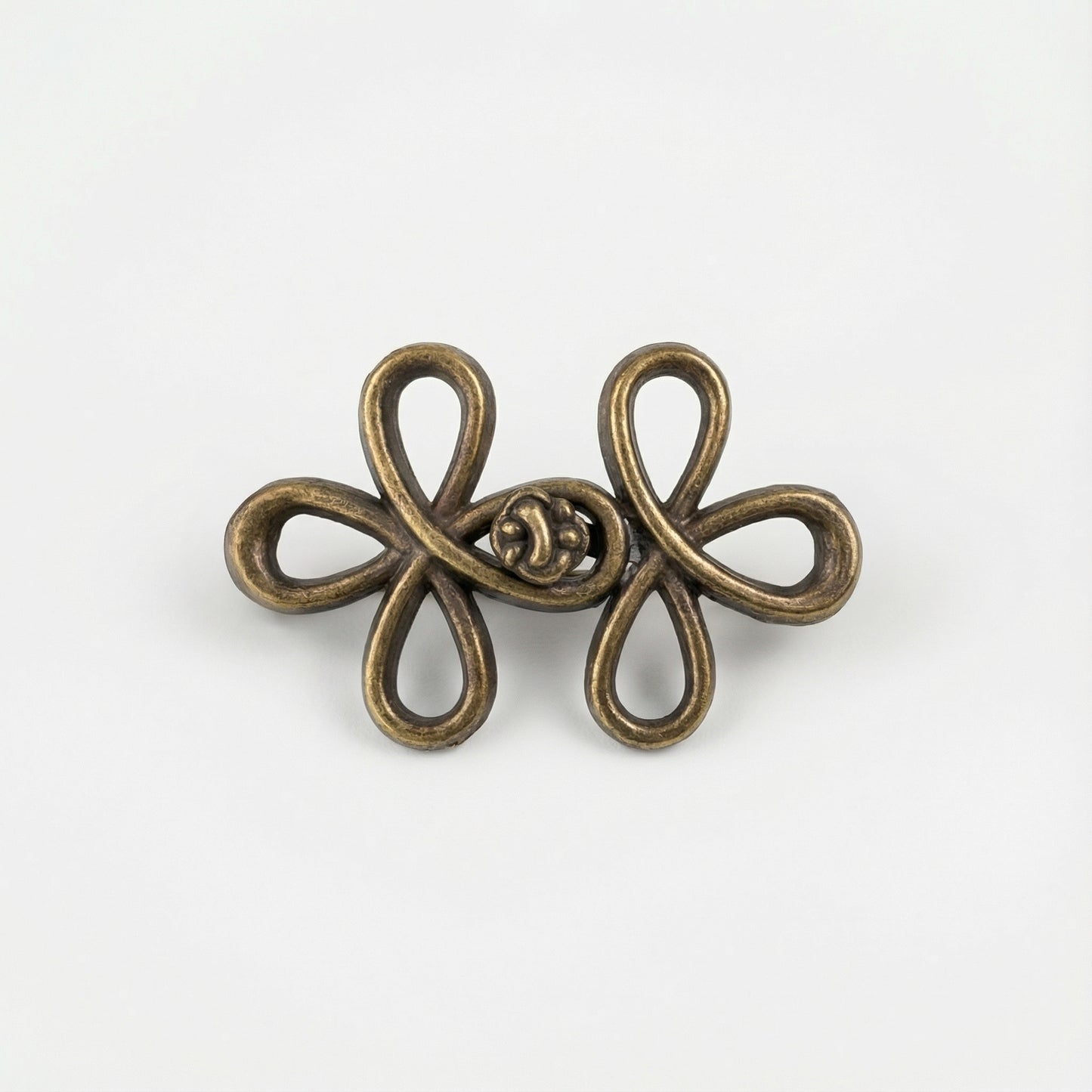 Bronze-colored decorative brooch on a white background