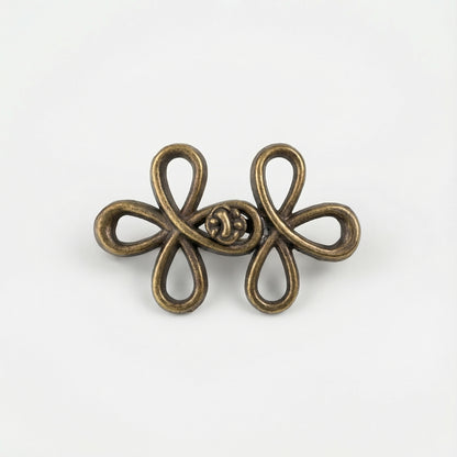 Bronze-colored decorative brooch on a white background