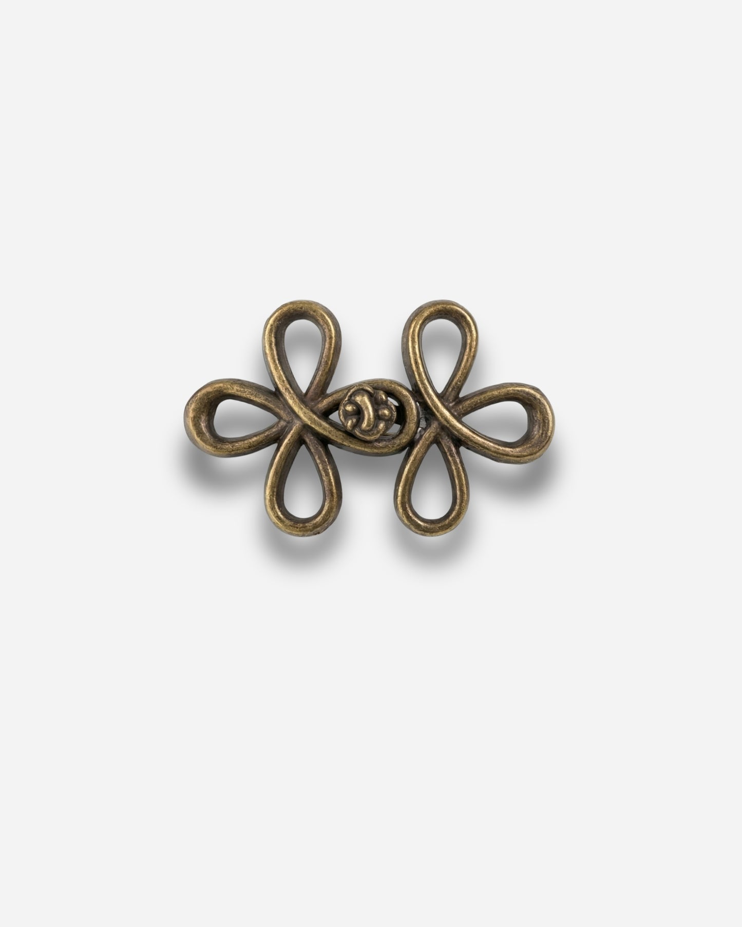 Bronze decorative clasp with a floral design on a plain background.