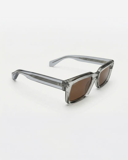 Gray sunglasses with brown lenses on a plain white background.