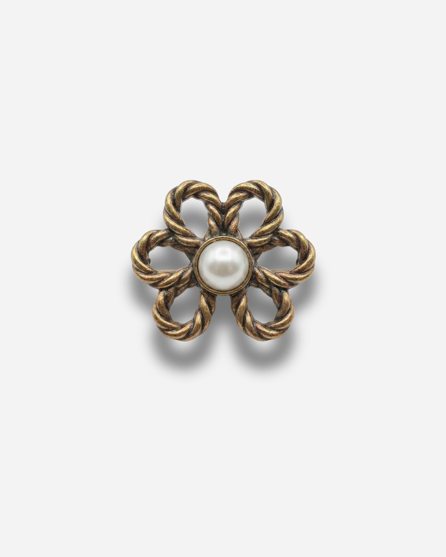 Gold flower-shaped brooch with a central pearl.