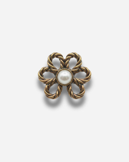 Gold flower-shaped brooch with a central pearl.