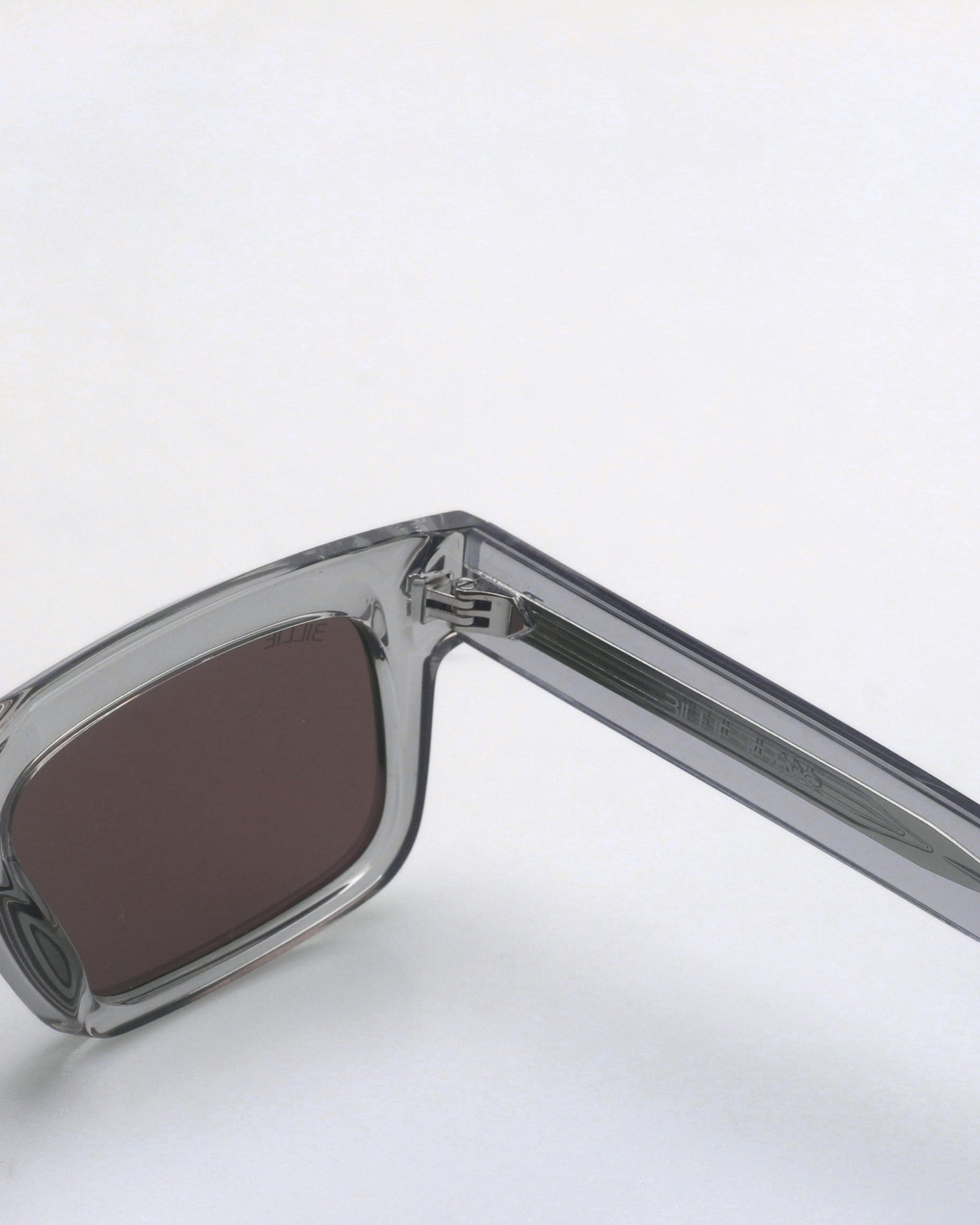 Gray sunglasses with dark lenses on a plain background