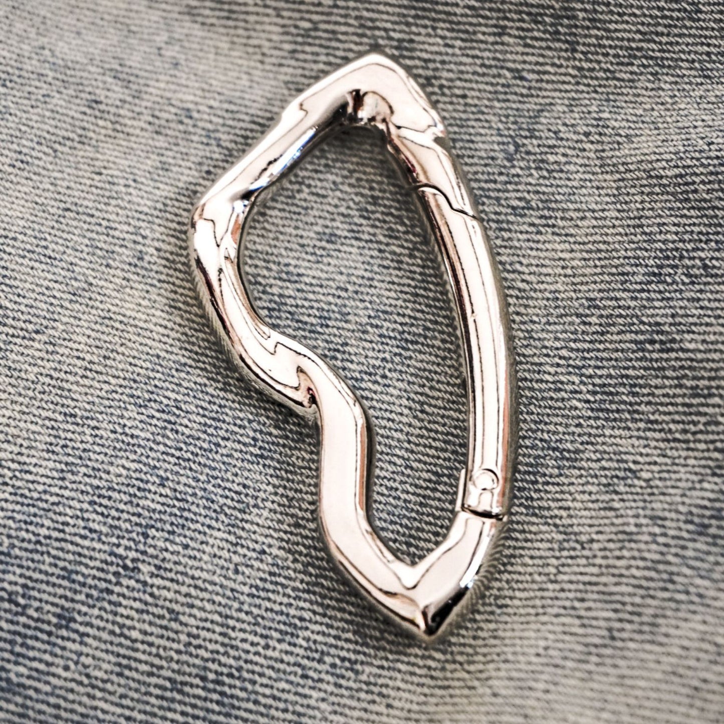 chrome carabiner keychain on denim 