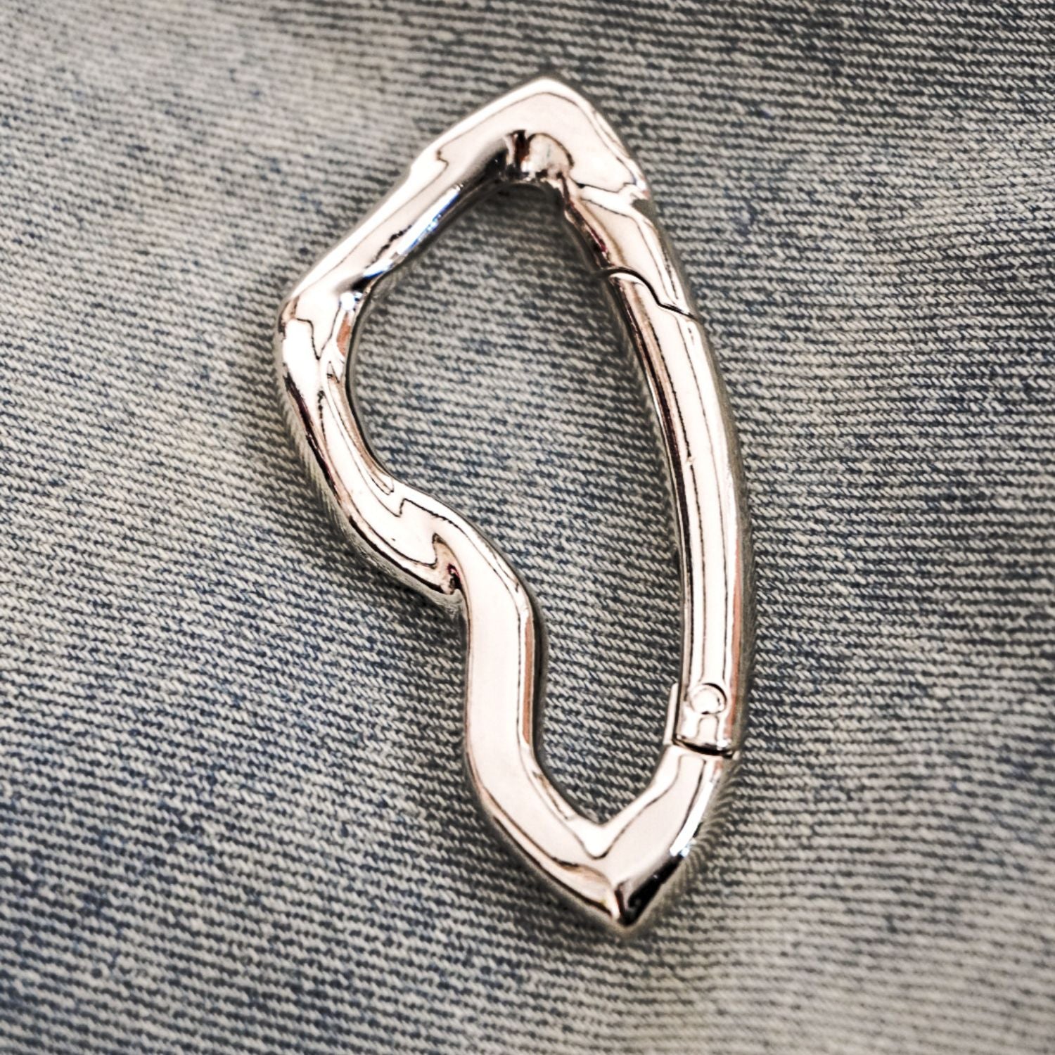 chrome carabiner keychain on denim 